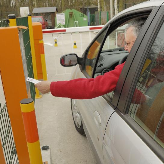 man zit in wagen en badget aan slagboom